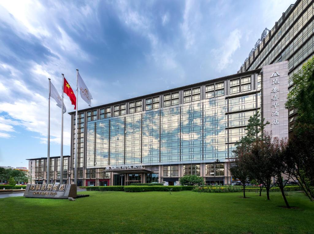 un edificio con dos banderas delante en Beijing Kuntai Royal Hotel, en Beijing