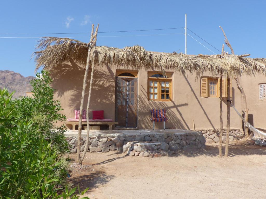 a small house with a thatch roof at Think Love on Red Sea in Nuweiba