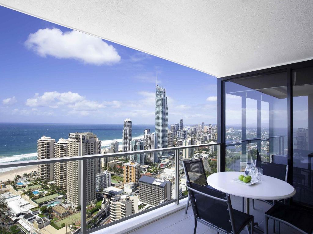 a balcony with a table and chairs and a view of the city at Mantra Circle On Cavill in Gold Coast