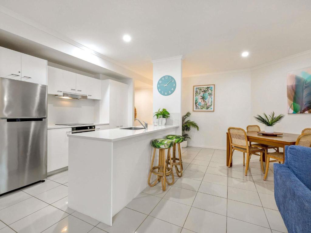 a kitchen and living room with a table and chairs at Mantra Amphora in Palm Cove