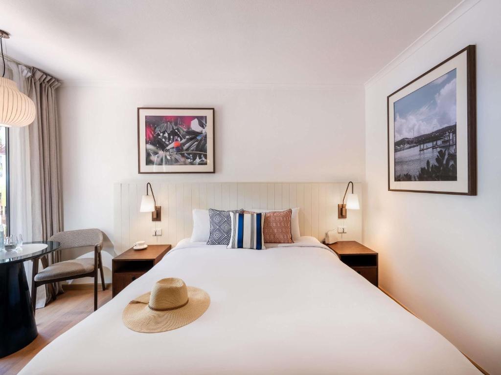 a hotel room with a bed with a hat on it at Mantra Club Croc in Airlie Beach