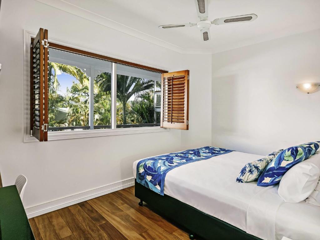 a bedroom with a bed and a window at Mantra on the Inlet in Port Douglas