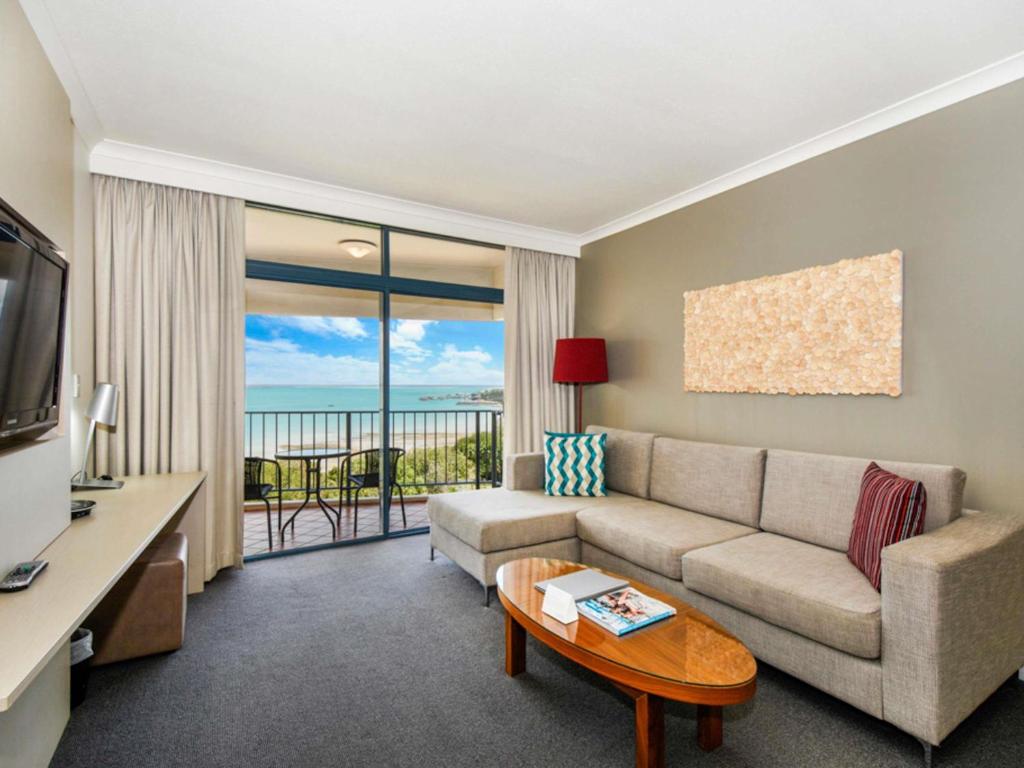 a living room with a couch and a table at Mantra on The Esplanade in Darwin
