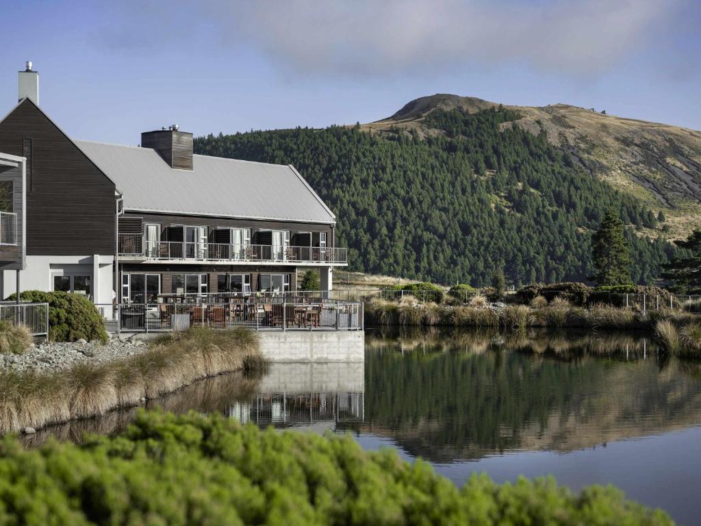 ein Haus neben einem Fluss mit einem Berg in der Unterkunft Peppers Bluewater Resort in Lake Tekapo