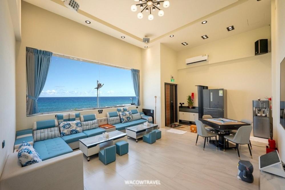 小琉球岛小琉球暮光停琉海景包棟民宿的客厅里有一张蓝色的沙发，可以看到海景