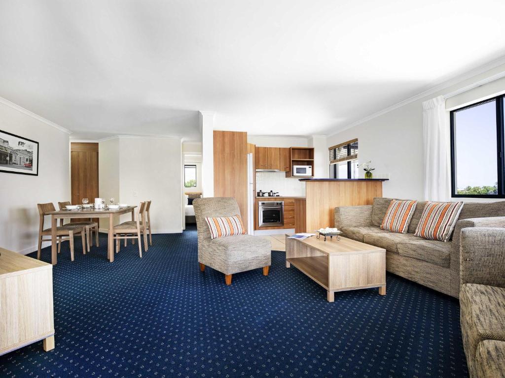 a living room with a couch and a table at Mantra Hervey Bay in Hervey Bay