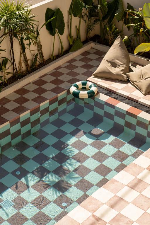 a room with a checkered floor with a couch at Teddies in Ahangama
