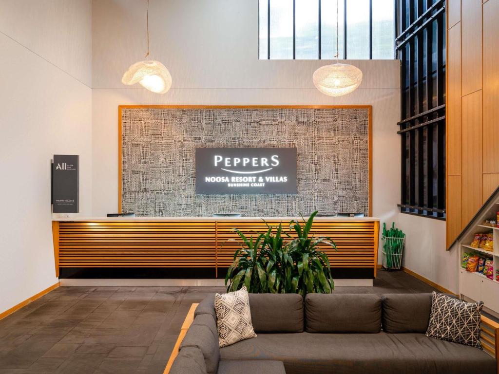 una hall con divano di fronte a un bancone di Peppers Noosa Resort and Villas a Noosa Heads