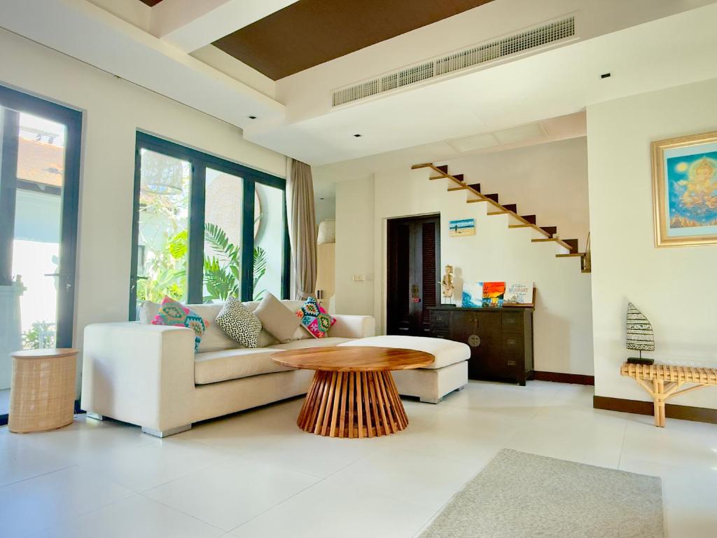 a living room with a couch and a table at Phuket Hideaway Near Bang Tao in Laguna Phuket