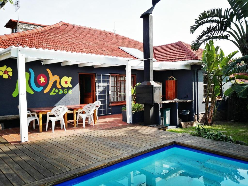 a house with a table and a swimming pool at Aloha Lodge in Cape Town