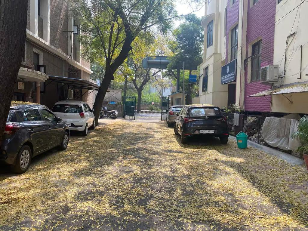 a street with cars parked on the sides of buildings at Cosy and Comfortable Cottage in South Delhi in New Delhi