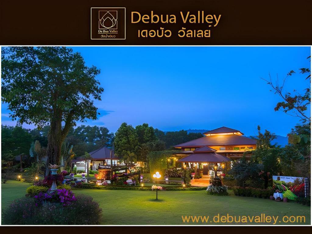 a night view of a garden with a restaurant at De Bua Valley in Ban Kom