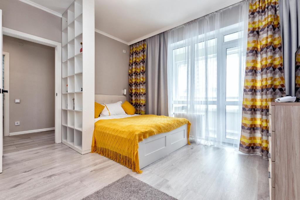 1 dormitorio con 1 cama con manta amarilla en Freedom, en Astana