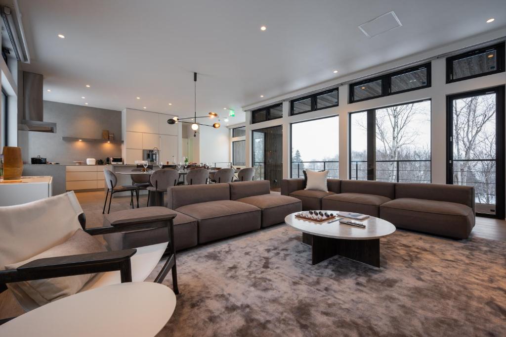a living room with a couch and a table at Mokuren by H2 Life in Niseko