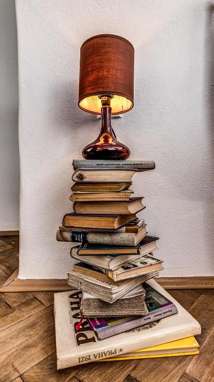 a lamp sitting on top of a stack of books at Studio Nicolas Prague in Prague