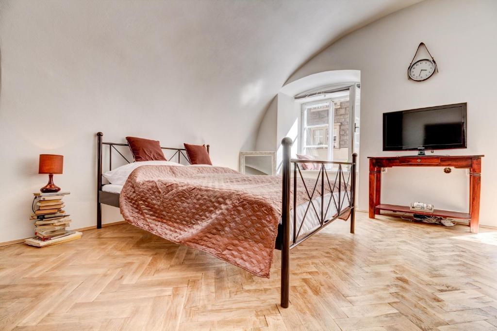 a bedroom with a bed and a flat screen tv at Studio Nicolas Prague in Prague
