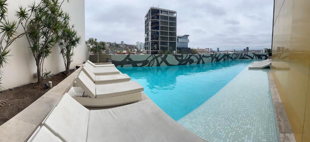 una piscina con agua azul en un edificio en Adamant Toreo, en Tijuana