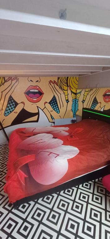 een bed met een schilderij aan de muur bij studio pop art in Saint-Philbert-sur-Risle