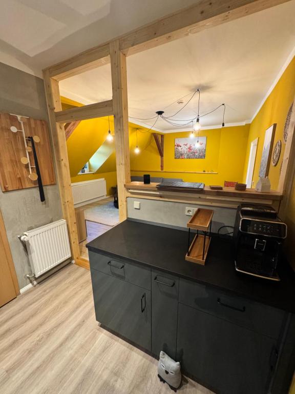 une cuisine avec des murs jaunes et un comptoir noir dans l'établissement Altstadt Quartier 2, à Bad Freienwalde