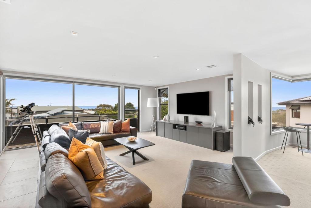 un soggiorno con un divano e una televisione di Manna Heaven Luxury Coastal Retreat with Pool a Torquay