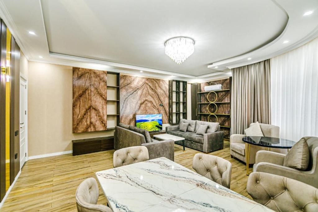 una sala de estar con una mesa y sillas en Khatai Deluxe Apartman, en Mekhrably