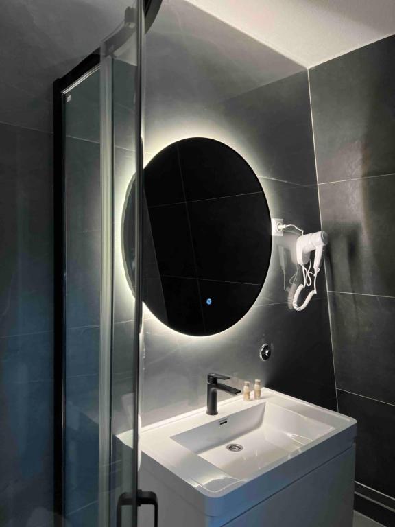 ein Badezimmer mit Waschbecken und Spiegel an der Wand in der Unterkunft Villa Apartments Mirela in Vlasic