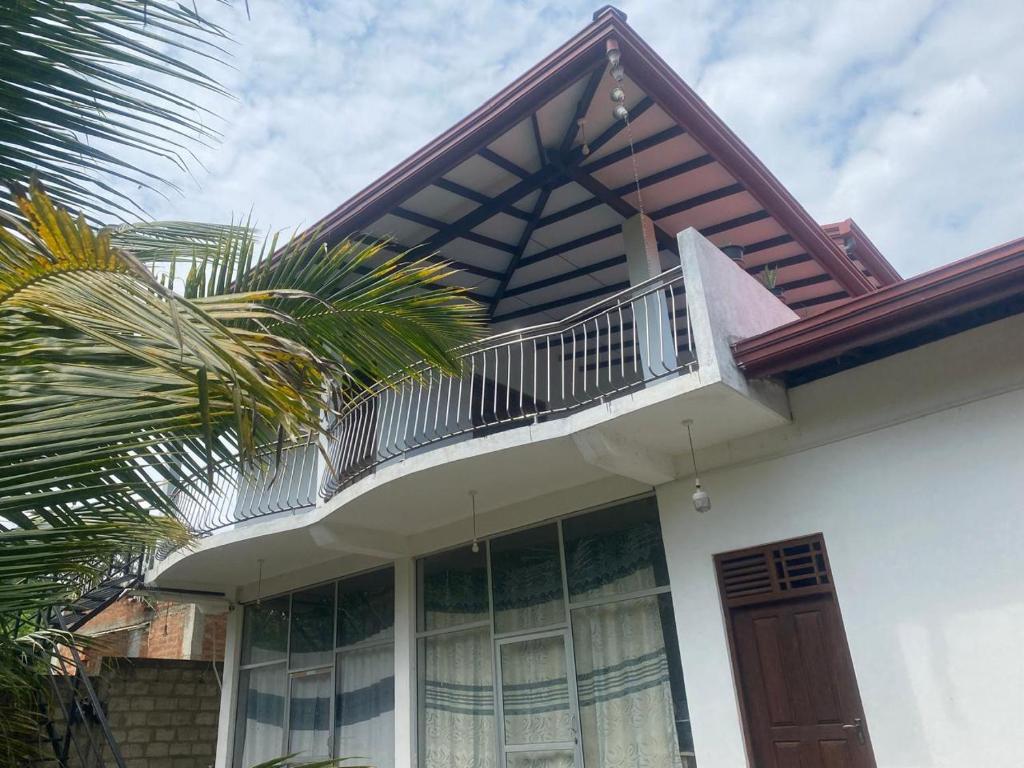 a house with a balcony on top of it at Sedasi Holiday Home in Tangalle