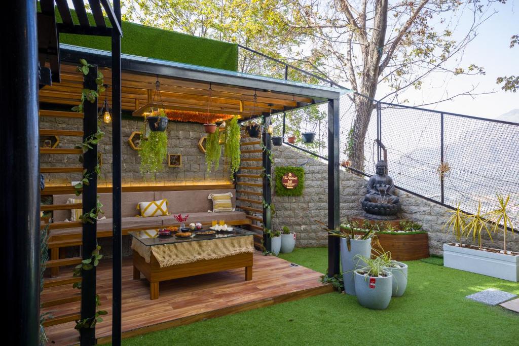 Un jardín con una pérgola y un banco en una terraza. en The Walnut Stays, en Solan