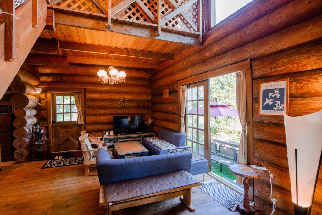 今津Forest Villa Ilio Biwako的小木屋内的客厅配有蓝色沙发