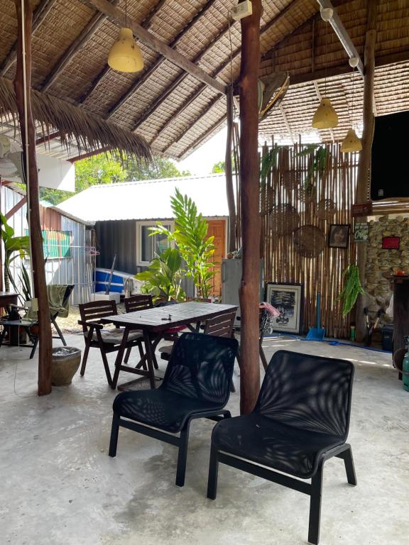 un patio con mesa, 2 sillas y una mesa en Pipin Garden, en Ban Khlong Kloi