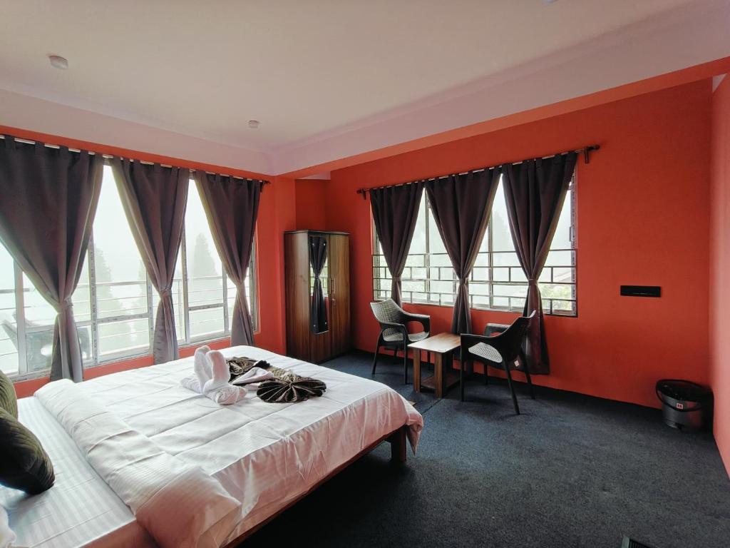 a bedroom with orange walls and a bed and a desk at Serenity Nest in Lava