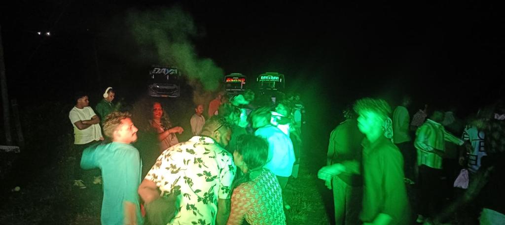 um grupo de pessoas em pé no escuro em സ്നേഹ തീരം em Vagamon