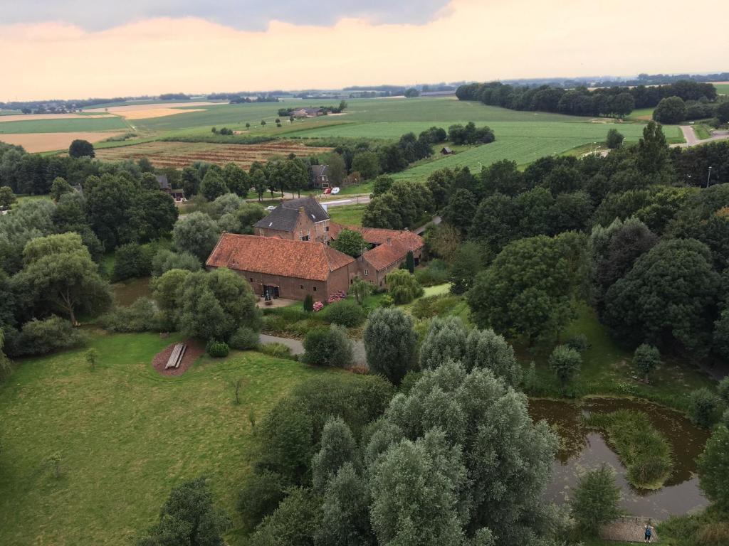 una vista aérea de una casa en un campo verde en Hotel Schinvelder Hoeve en Schinveld