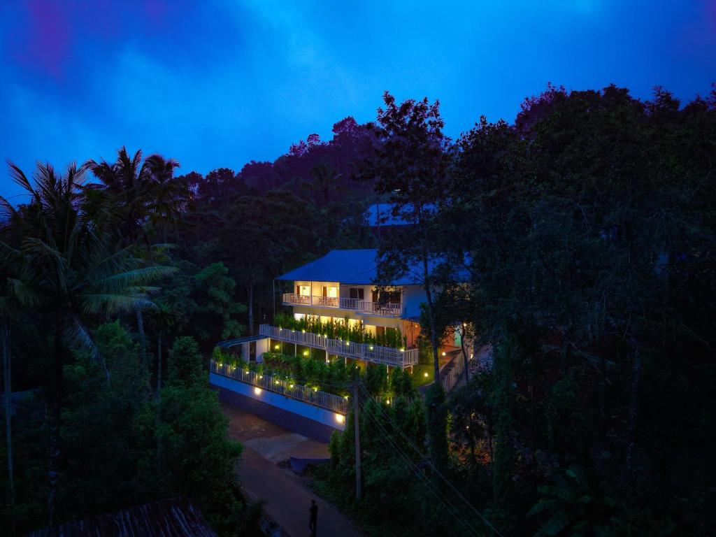 a building with lights on it at night at Ice Cloud Munnar Pool Resort in Munnar