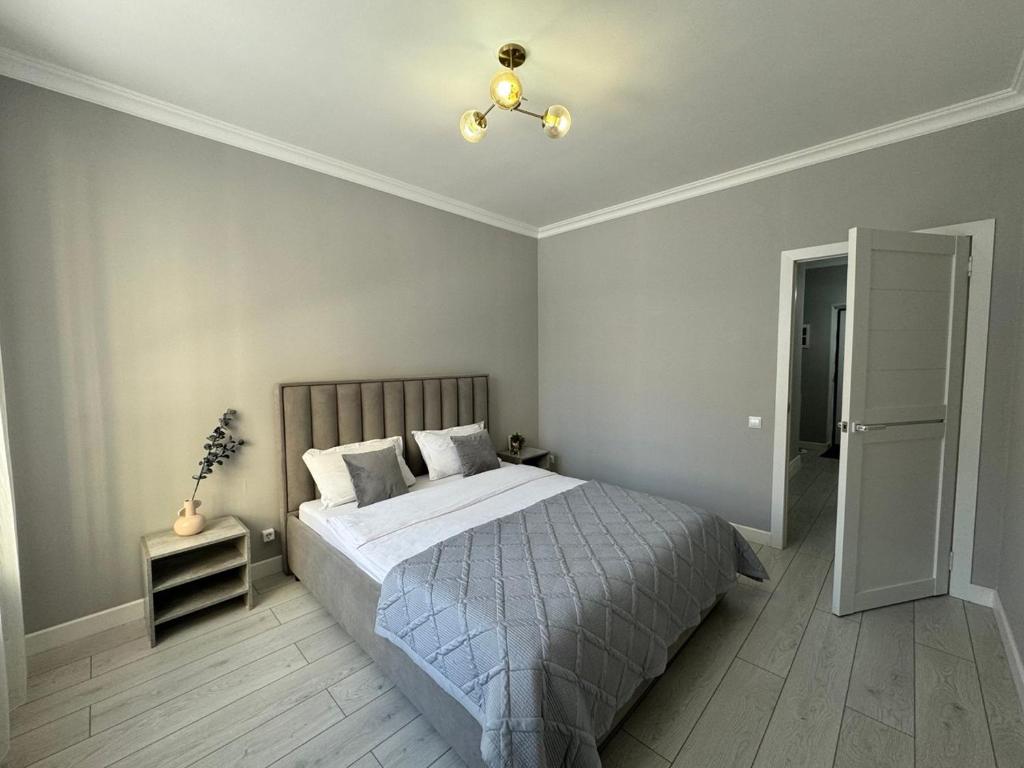 ein Schlafzimmer mit einem Bett und einem Kronleuchter in der Unterkunft ЖК Only sun в 10 минутах от Аэропорта in Prigorodnyy