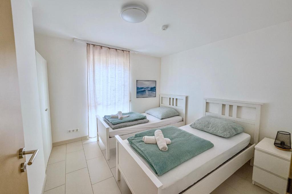 a bedroom with two beds and a window at Deluxe Apartment Diamond in Friedrichshafen