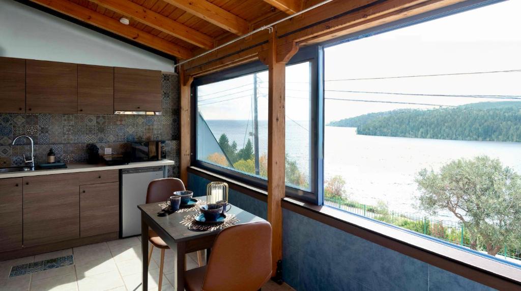 - une cuisine avec une table et une vue sur le lac dans l'établissement Cap Sounion Seafront Retreat, à Cap Sounion