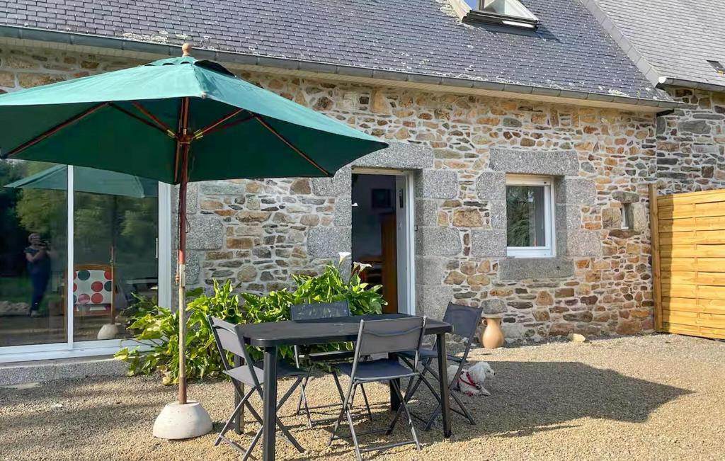 Trézény2 Bedroom Gorgeous Home In Rospez的大楼前的桌椅和雨伞