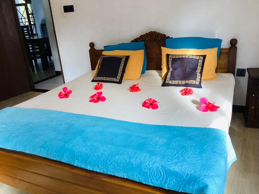 a bed with flowers on top of it at Nila Villa in Galle