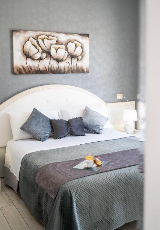 a bedroom with a bed with a painting on the wall at B&B PLAZA in Lampedusa