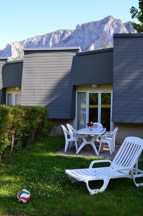 a patio with a table and chairs in front of a house at Chalets et Gites du Quié in Les Cabannes