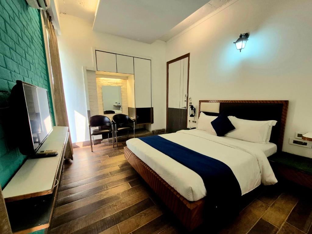 a bedroom with a bed and a flat screen tv at Stays - Golf Course Road in Gurgaon