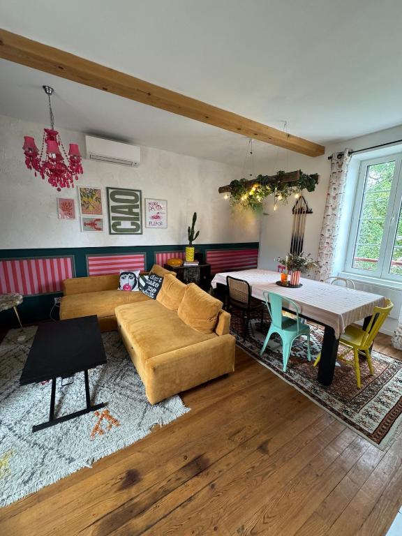 T3 Le Prima - Climatisation - Parking gratuit في بانيير-دوبيغور: غرفة معيشة مع أريكة وطاولة