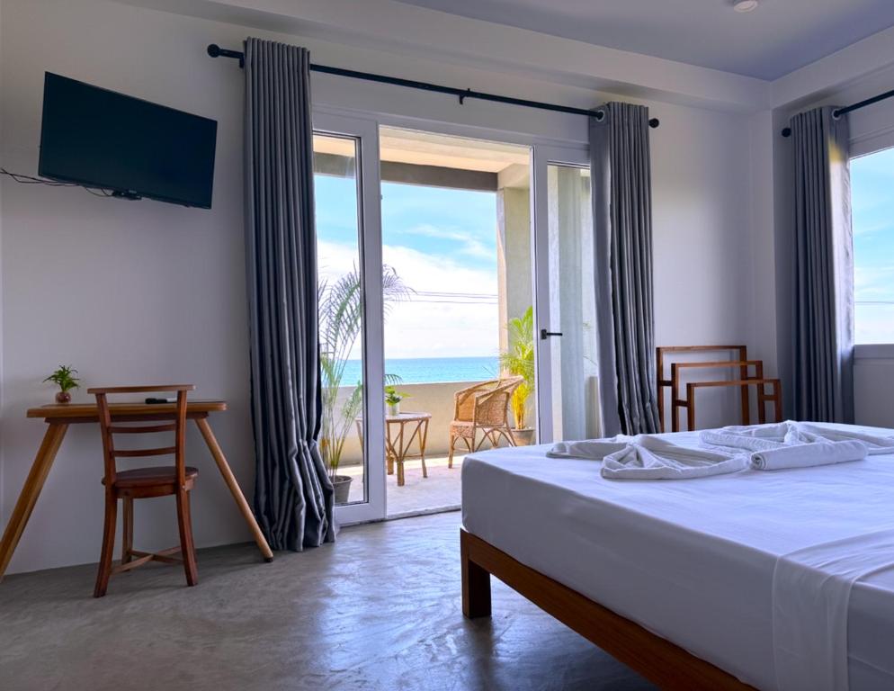 una habitación con cama y vistas a la playa en Goalie Beachfront Resort, en Hikkaduwa