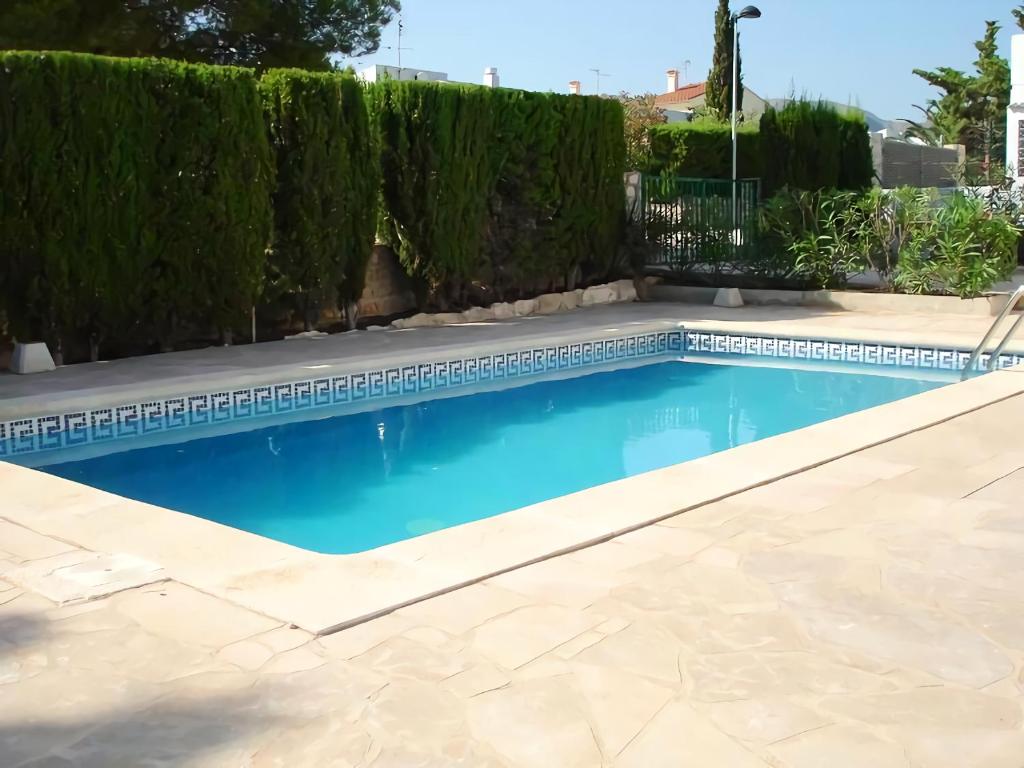 una piscina en un patio con un seto en Villa del Pi, en L'Ametlla de Mar