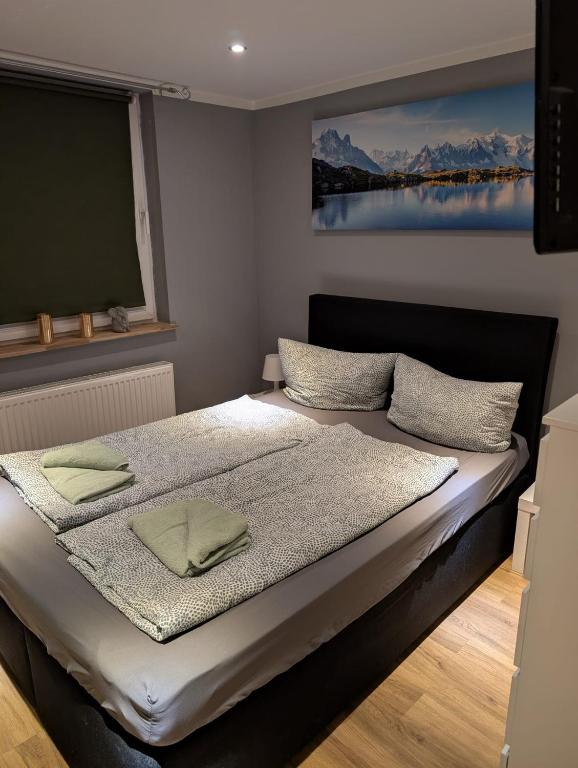 a bed in a room with a painting on the wall at Stadtnah an der Förde 5704 in Flensburg