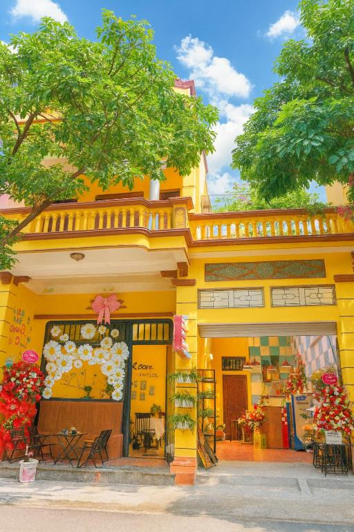 a store front of a yellow building with flowers at Bloom Homestay in Ninh Binh