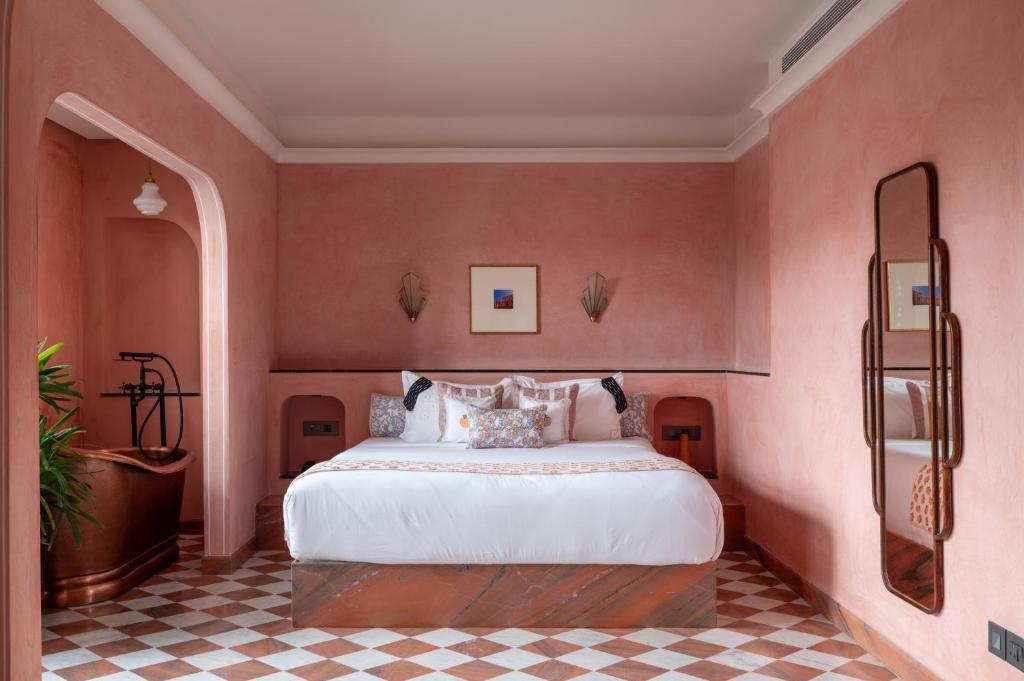 a bedroom with a large bed in a pink wall at Abode Jaipur in Jaipur