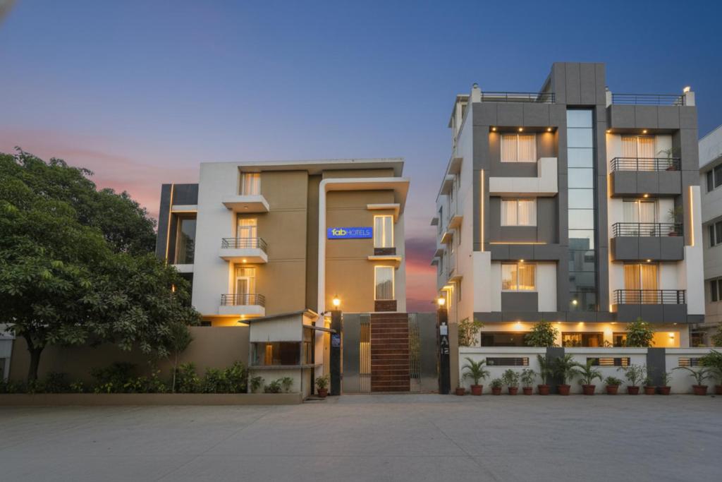 un immeuble d'appartements avec un coucher de soleil en arrière-plan dans l'établissement FabHotel Grand Olive, à Noida