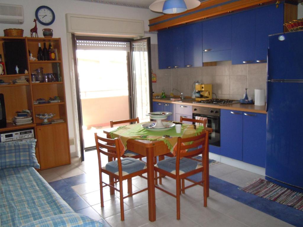 a kitchen with blue cabinets and a table and chairs at Casa Linda Taormina Etna in Fondachello